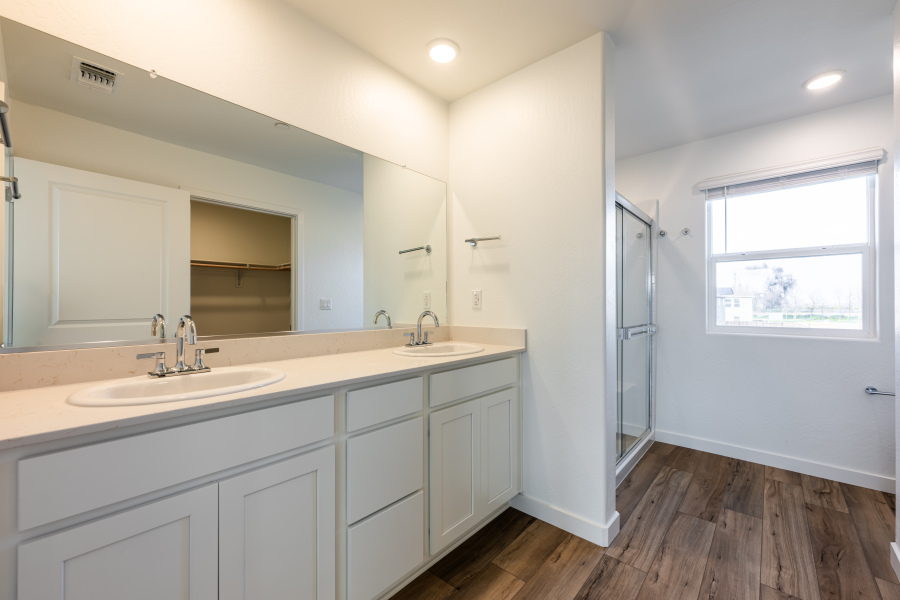 A bathroom with white cabinets.