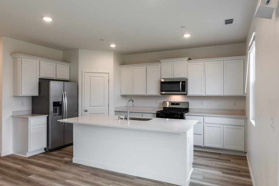 A kitchen with white cabinets.