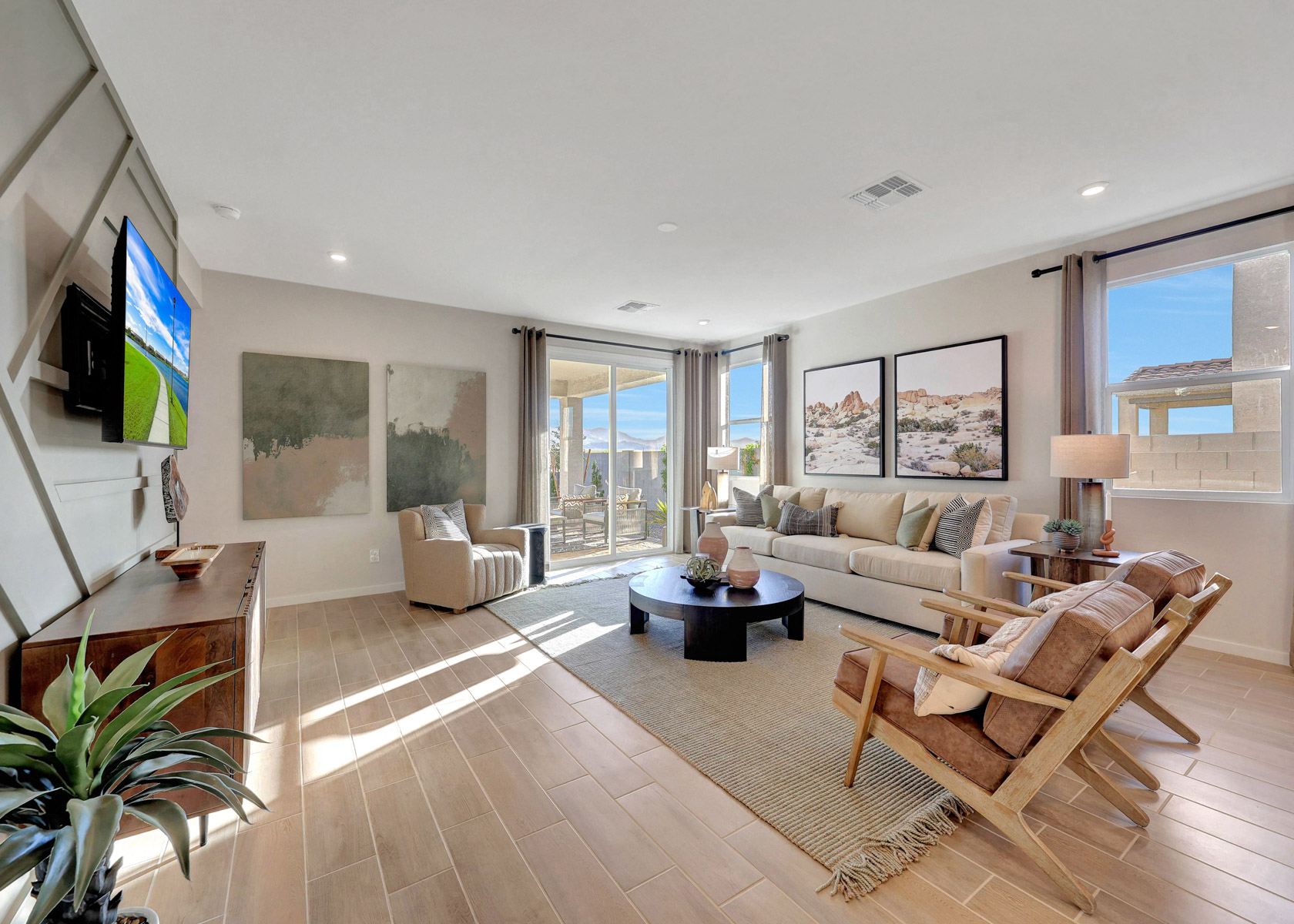 A living room with a large television and couches.