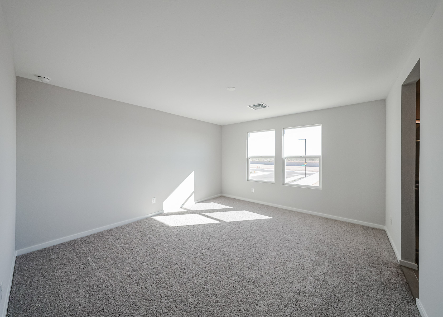 A room with a carpet and windows.