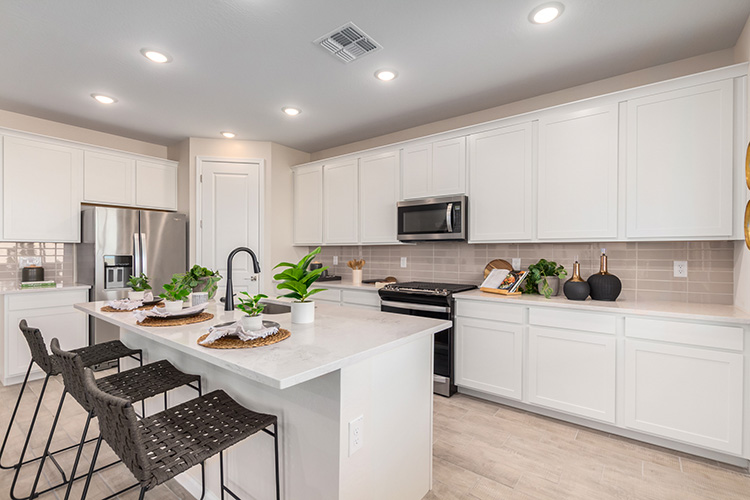 A kitchen with white cabinets.