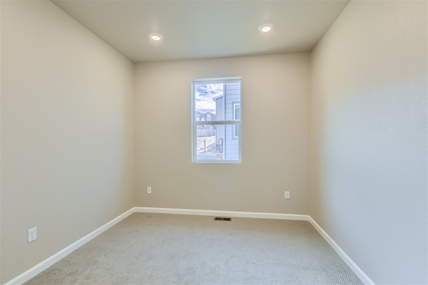 A room with a window and a carpet.