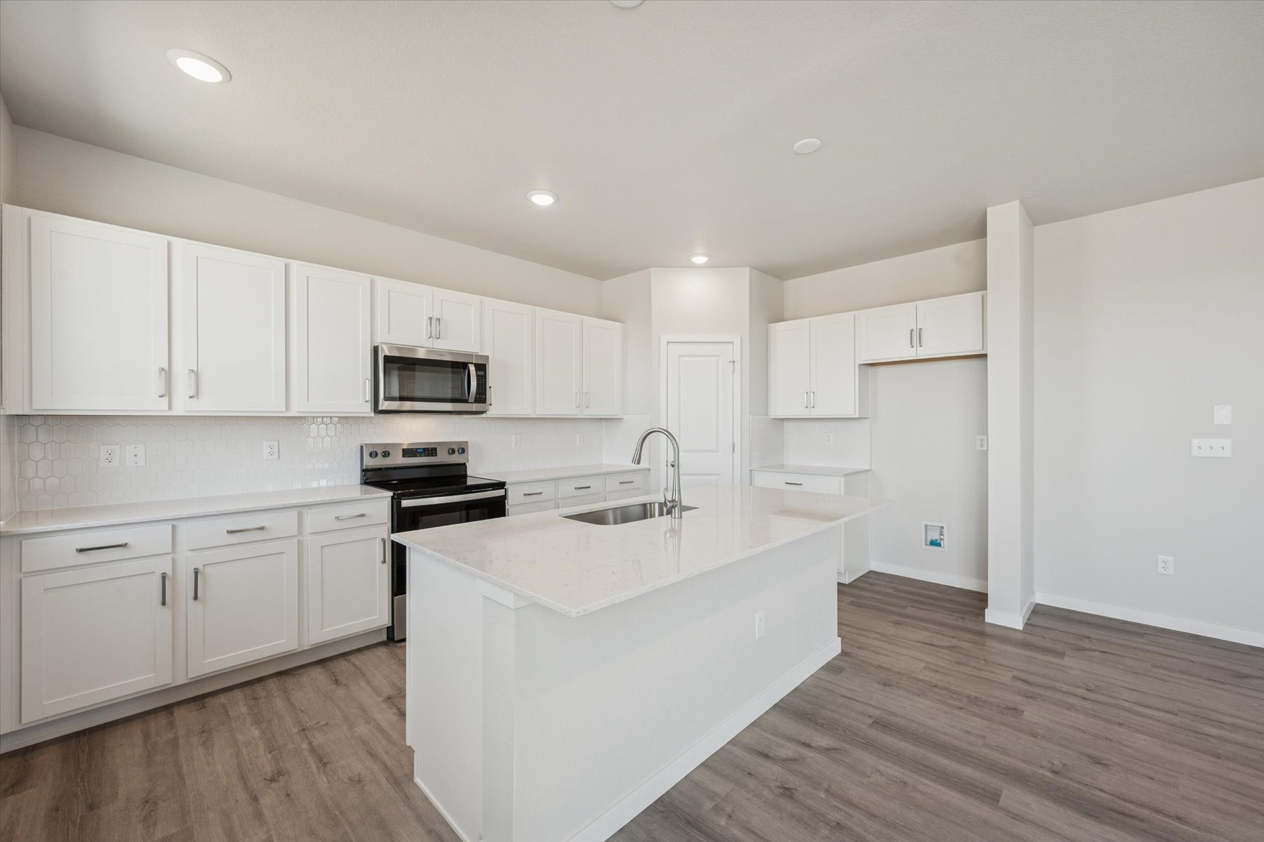 A kitchen with white cabinets.