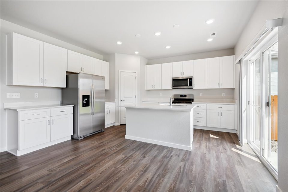 A kitchen with white cabinets.