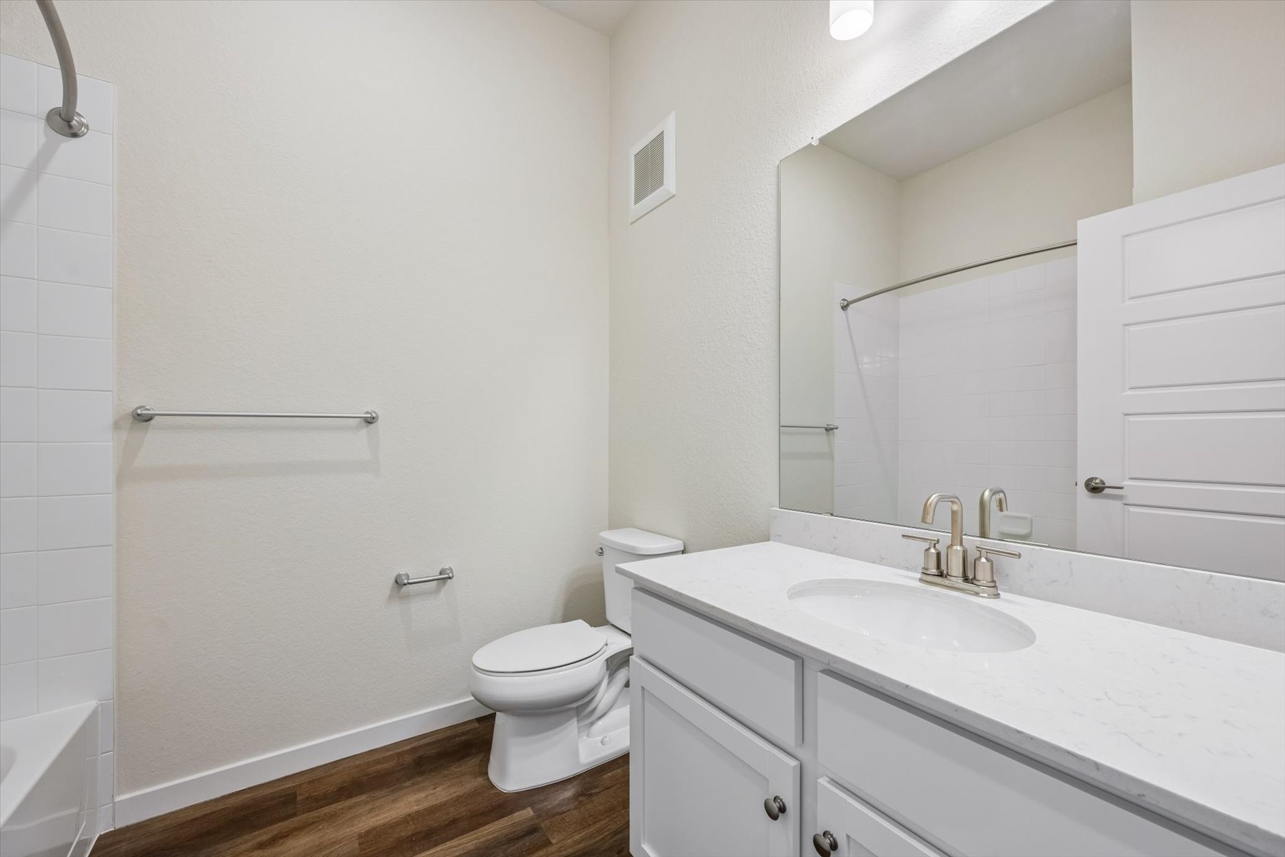 A bathroom with a sink toilet and mirror.