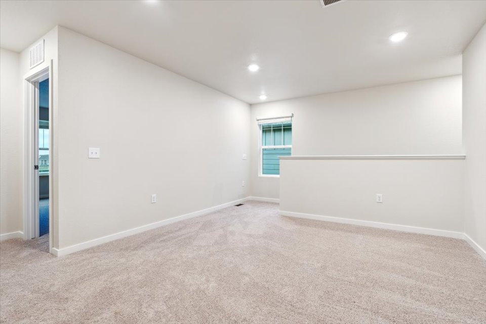 A room with a carpet and a window.