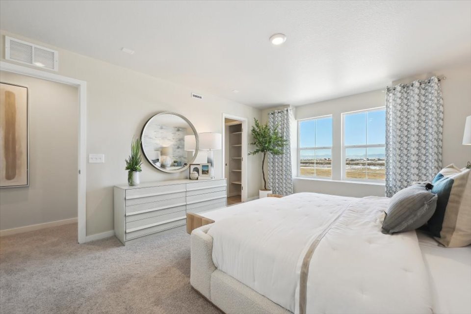 A bedroom with a large mirror.
