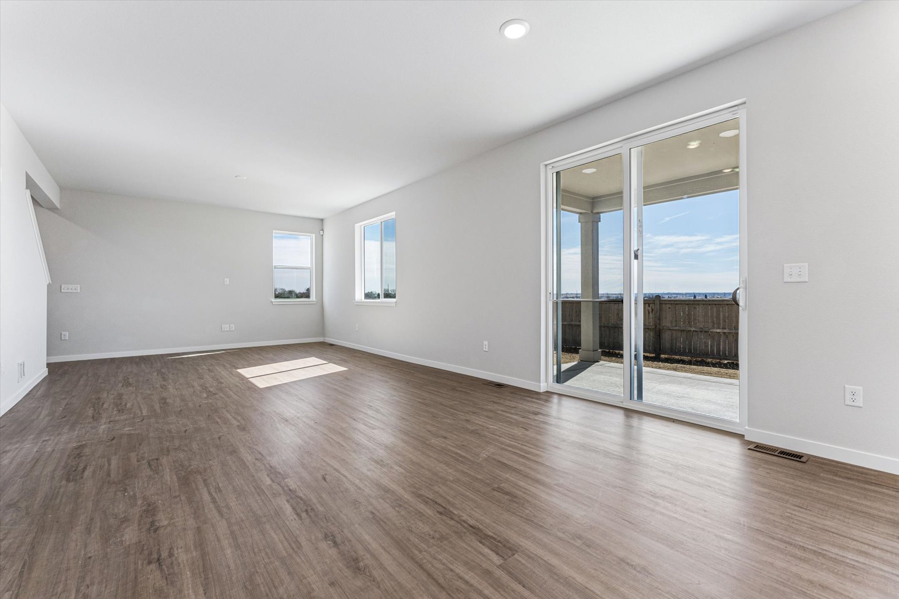 A room with a wood floor and a glass door.