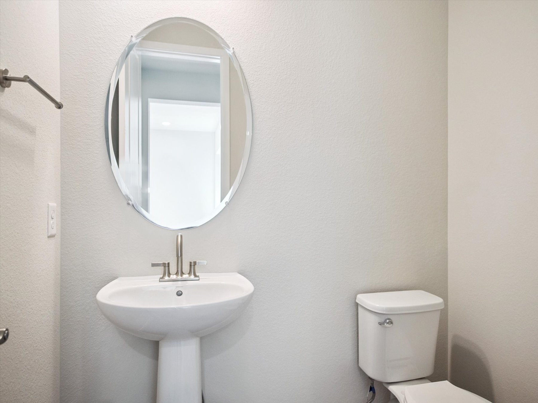 A bathroom with a round mirror.