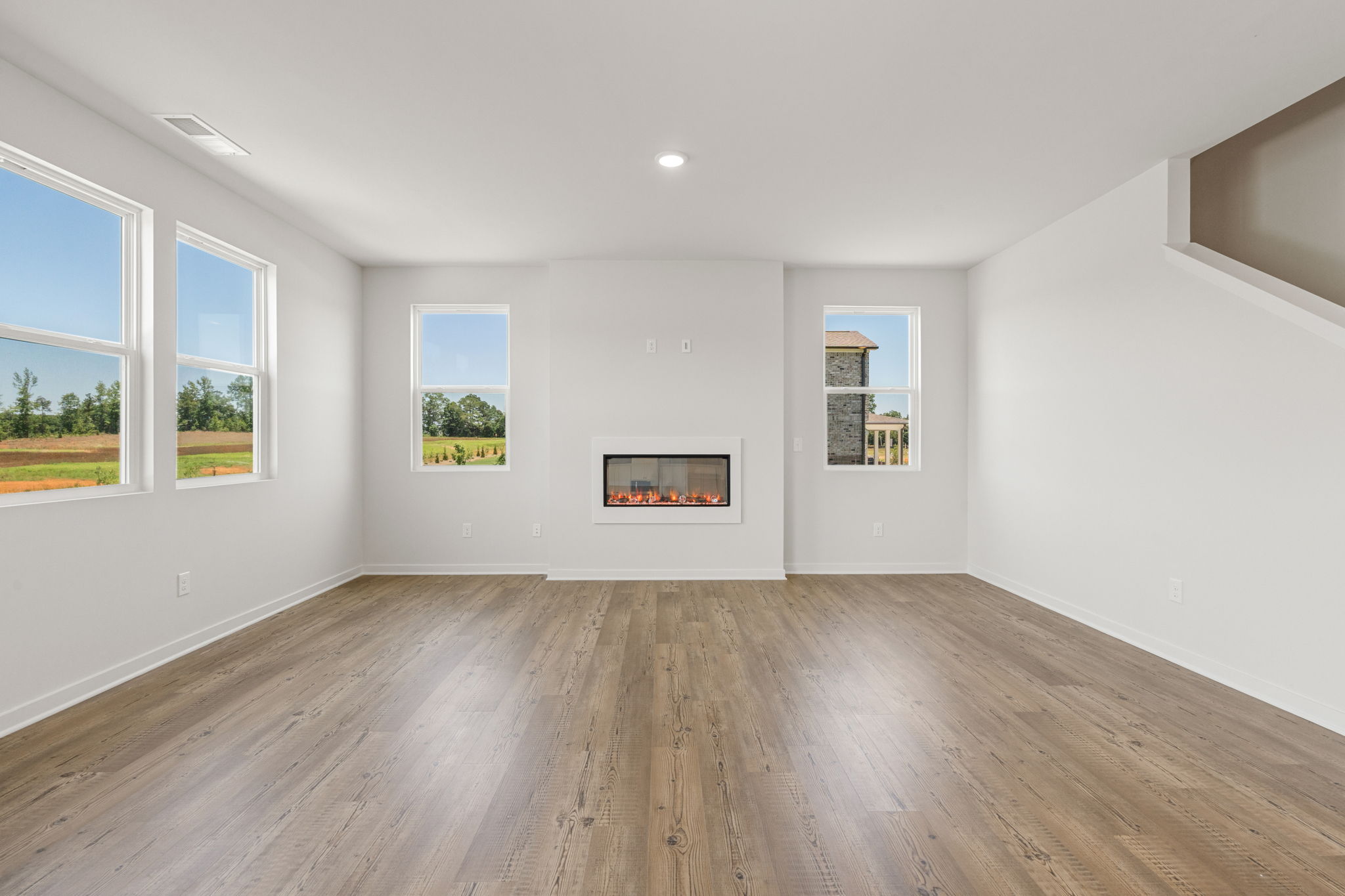 A room with a wood floor and windows.