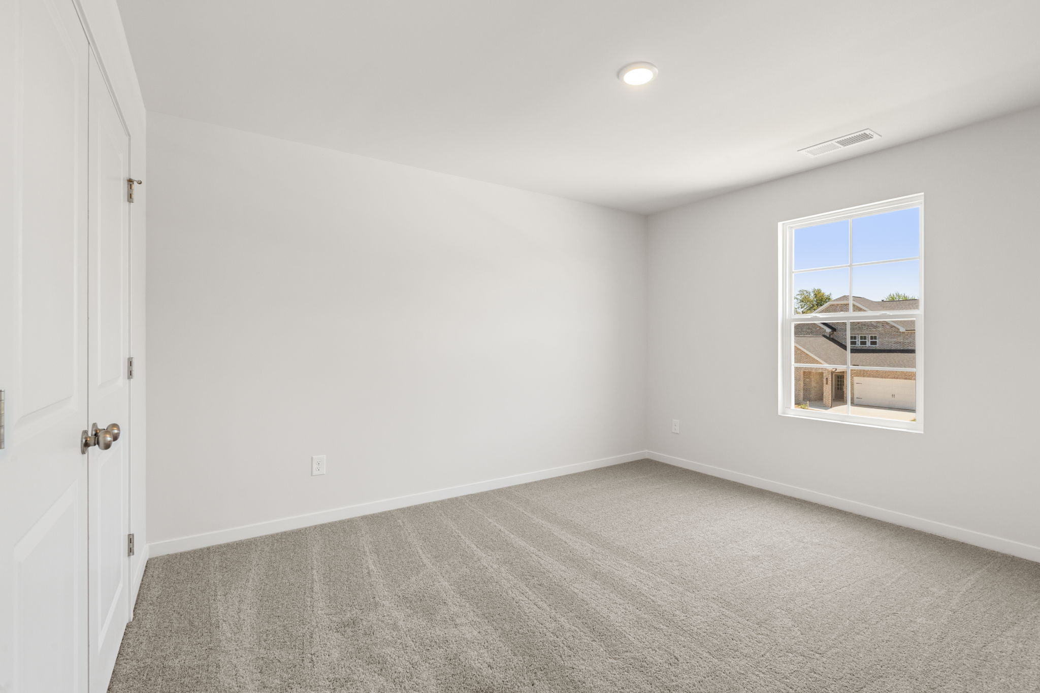 A room with a carpet and windows.