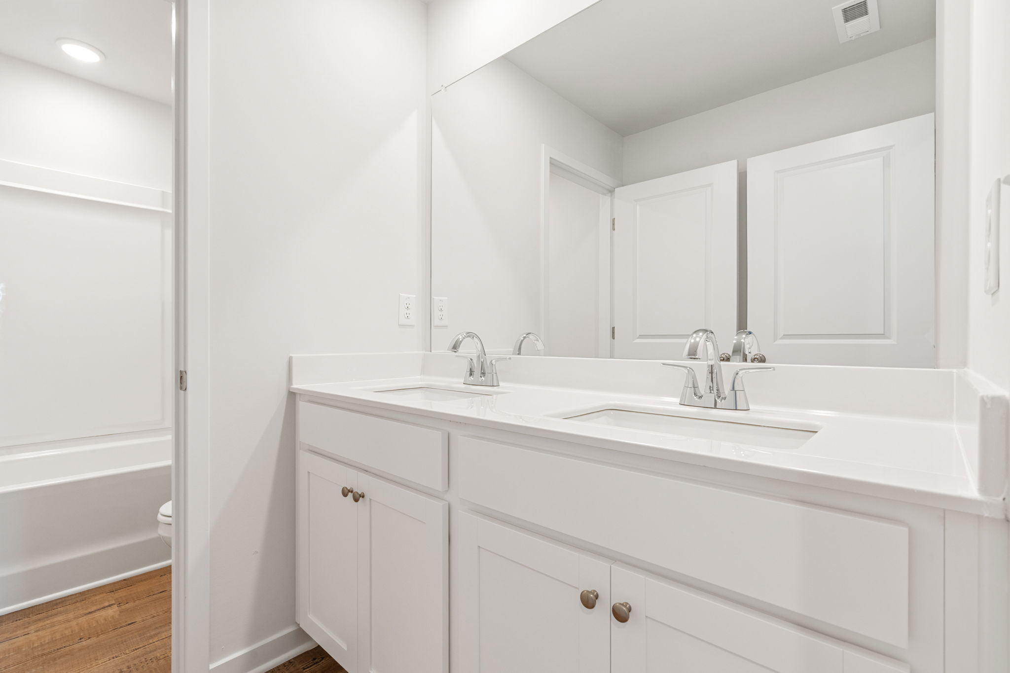 A bathroom with white cabinets.