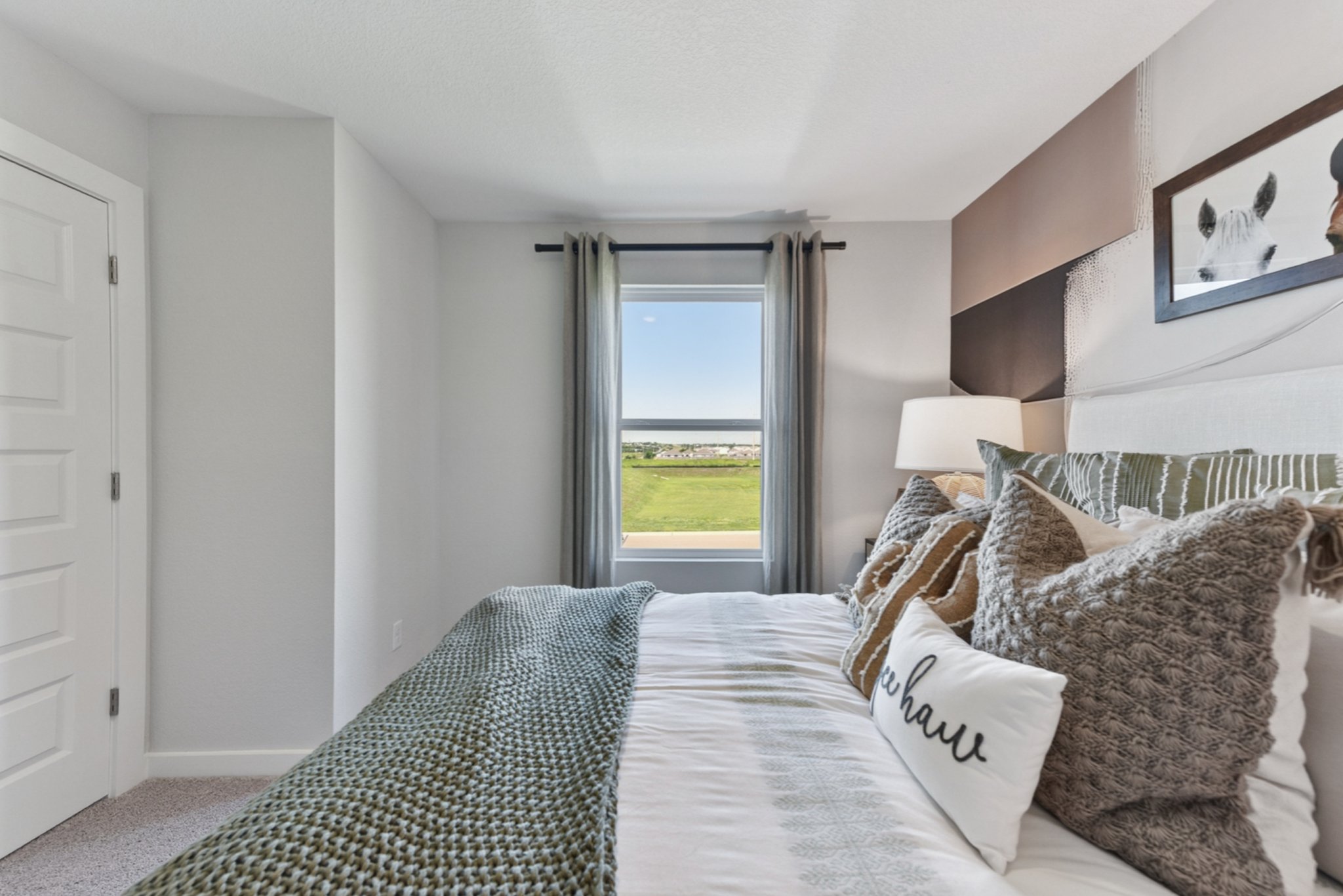 A bedroom with a large window.