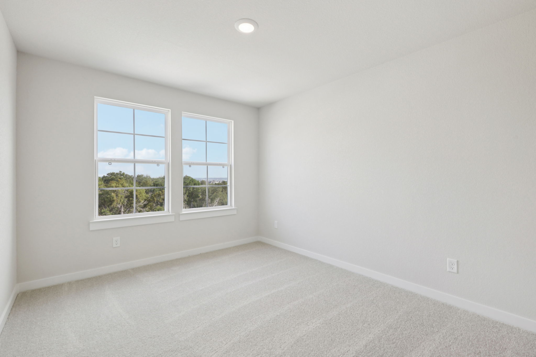 A room with a window and a white wall.