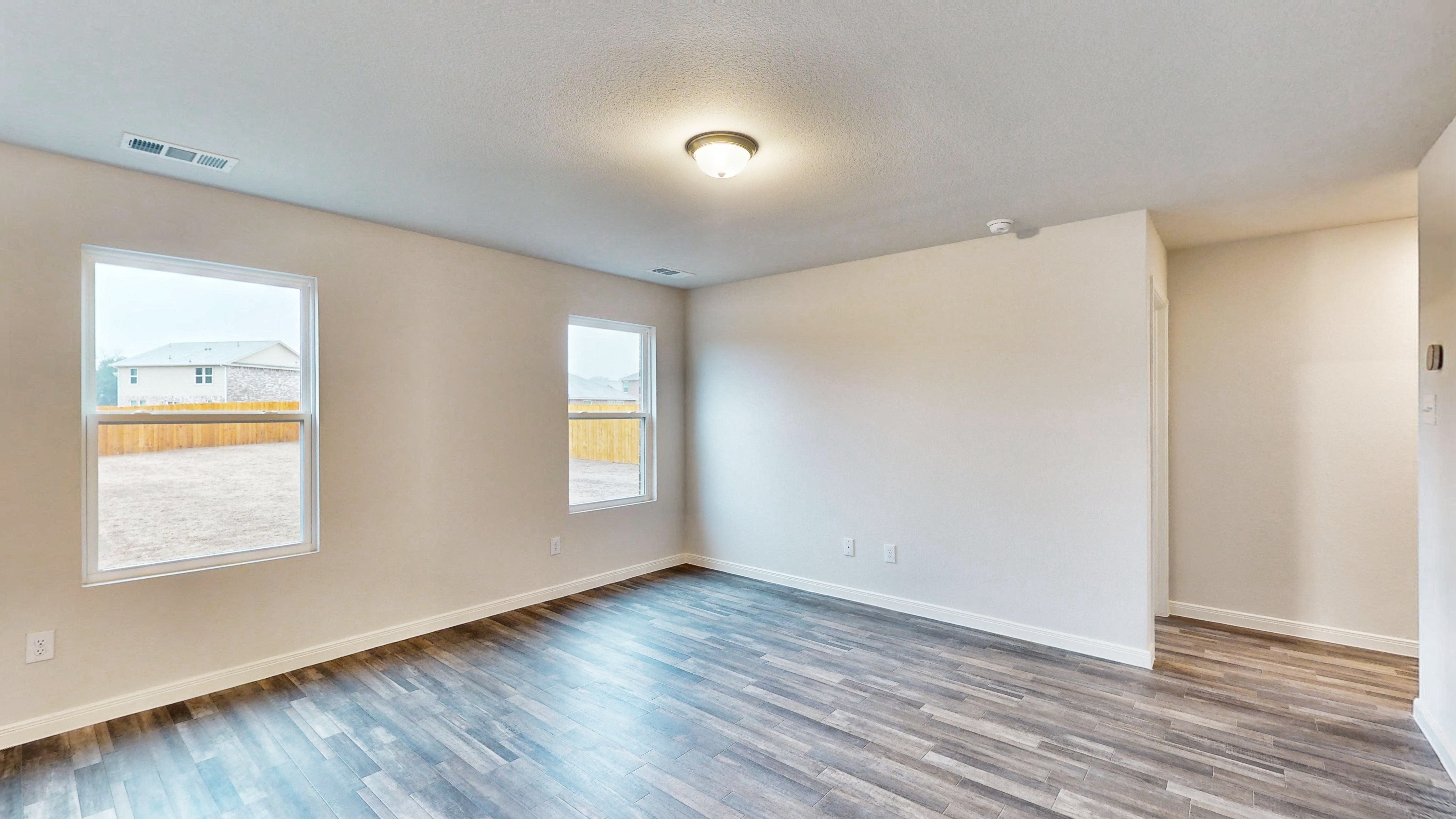 A room with a wood floor and a wood floor with a window.
