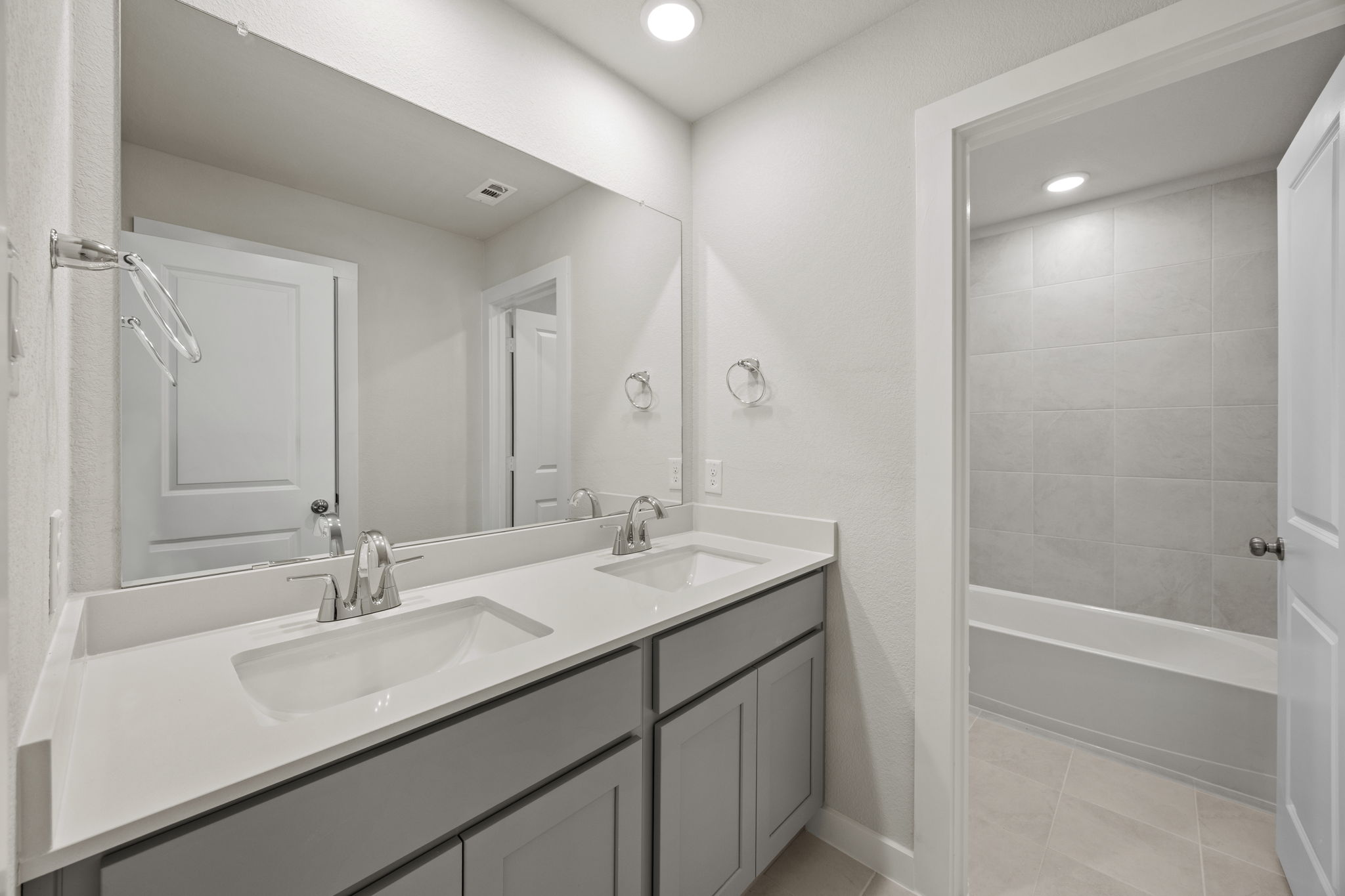 A bathroom with a sink and a shower unit.