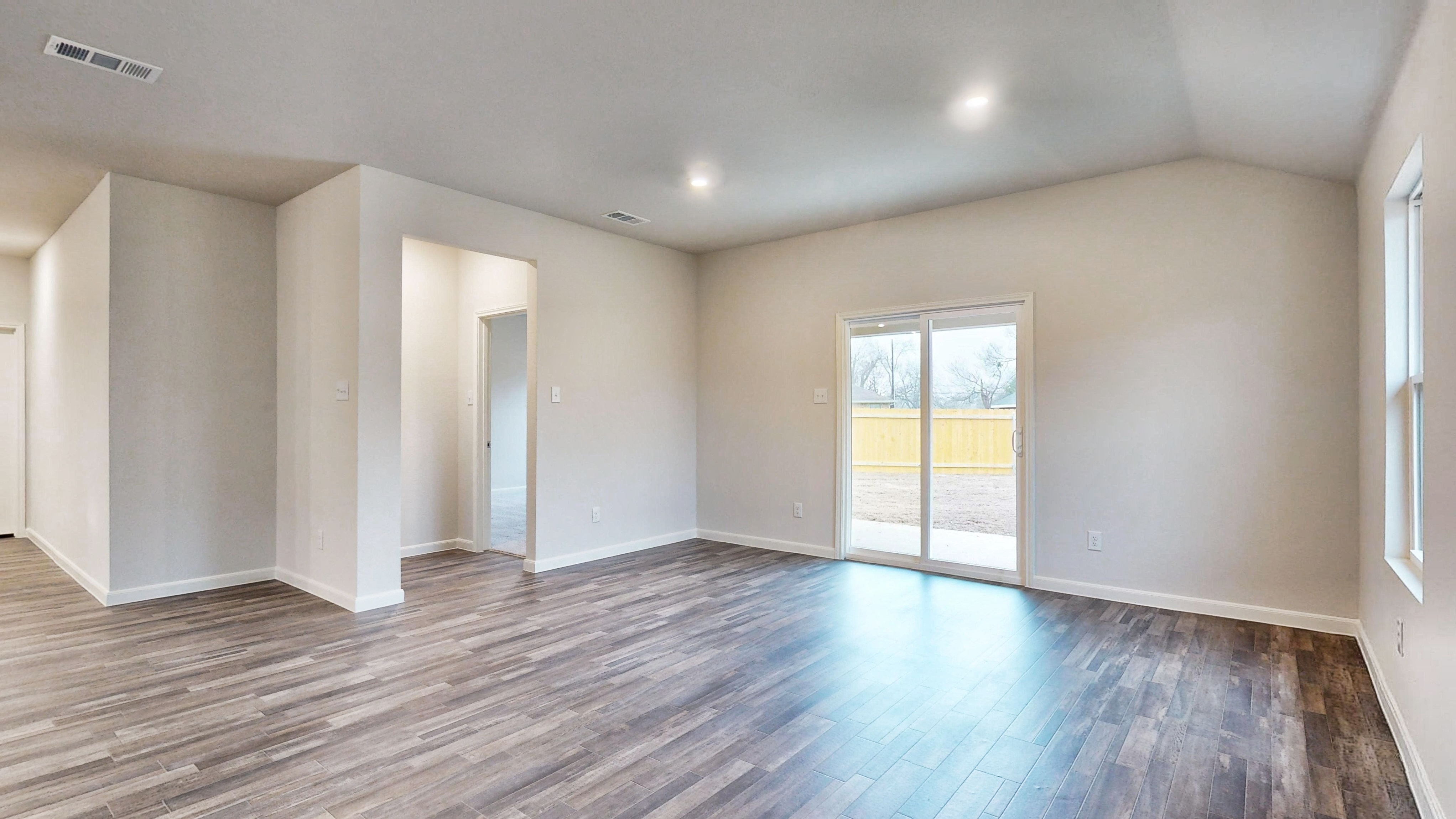 A room with a wood floor and a wood floor with a door.