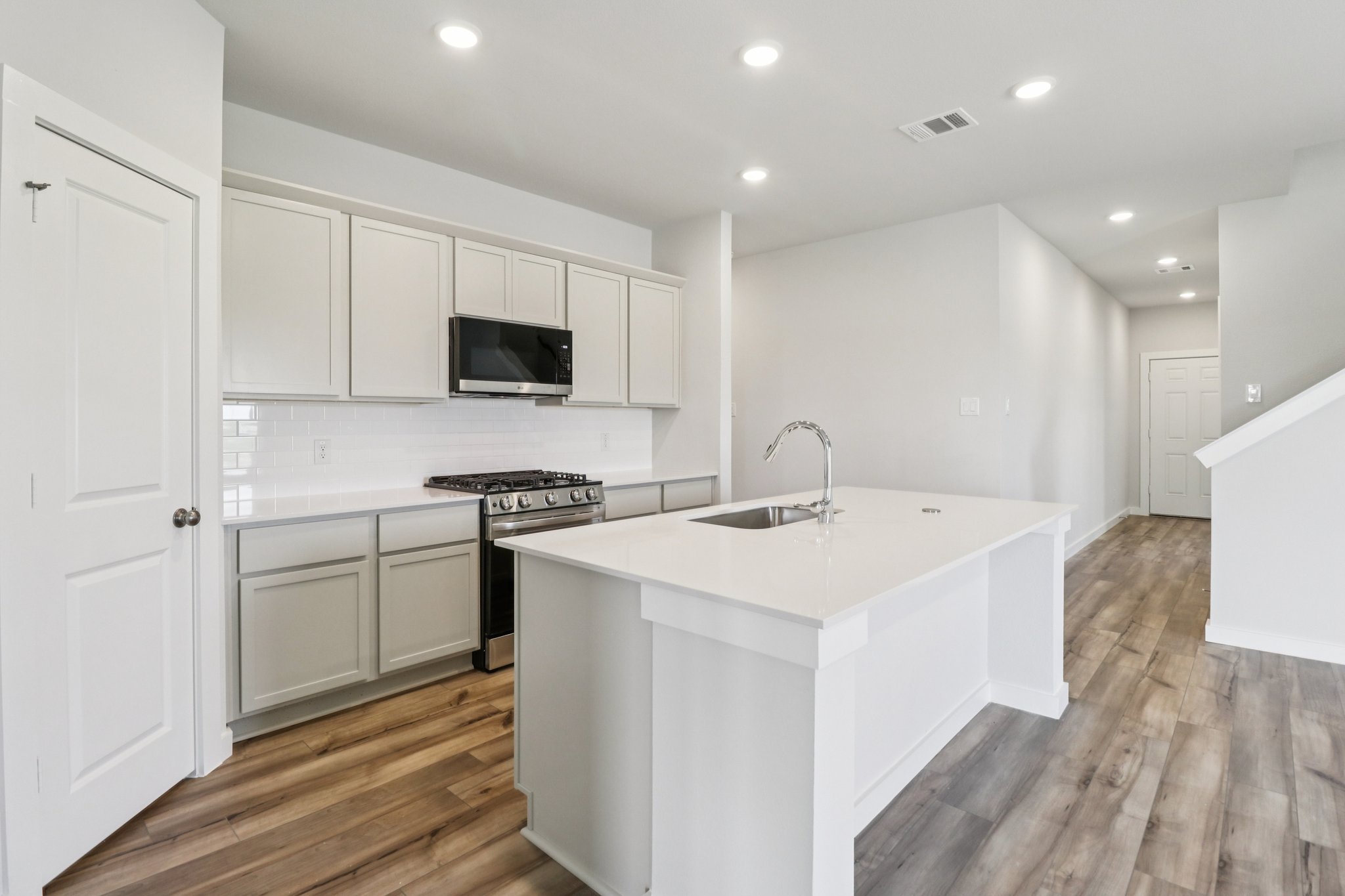 A kitchen with white cabinets.