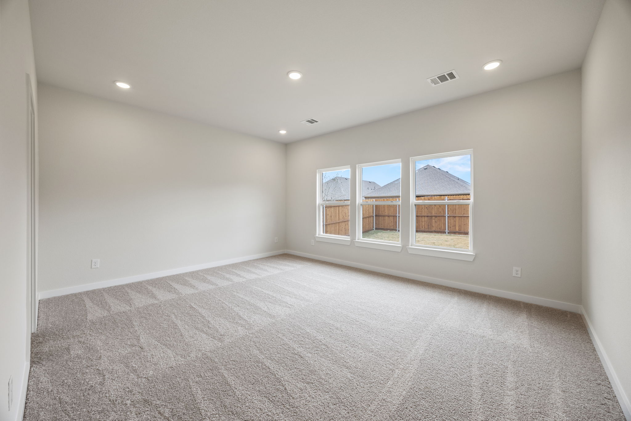 A room with a carpet and a window.