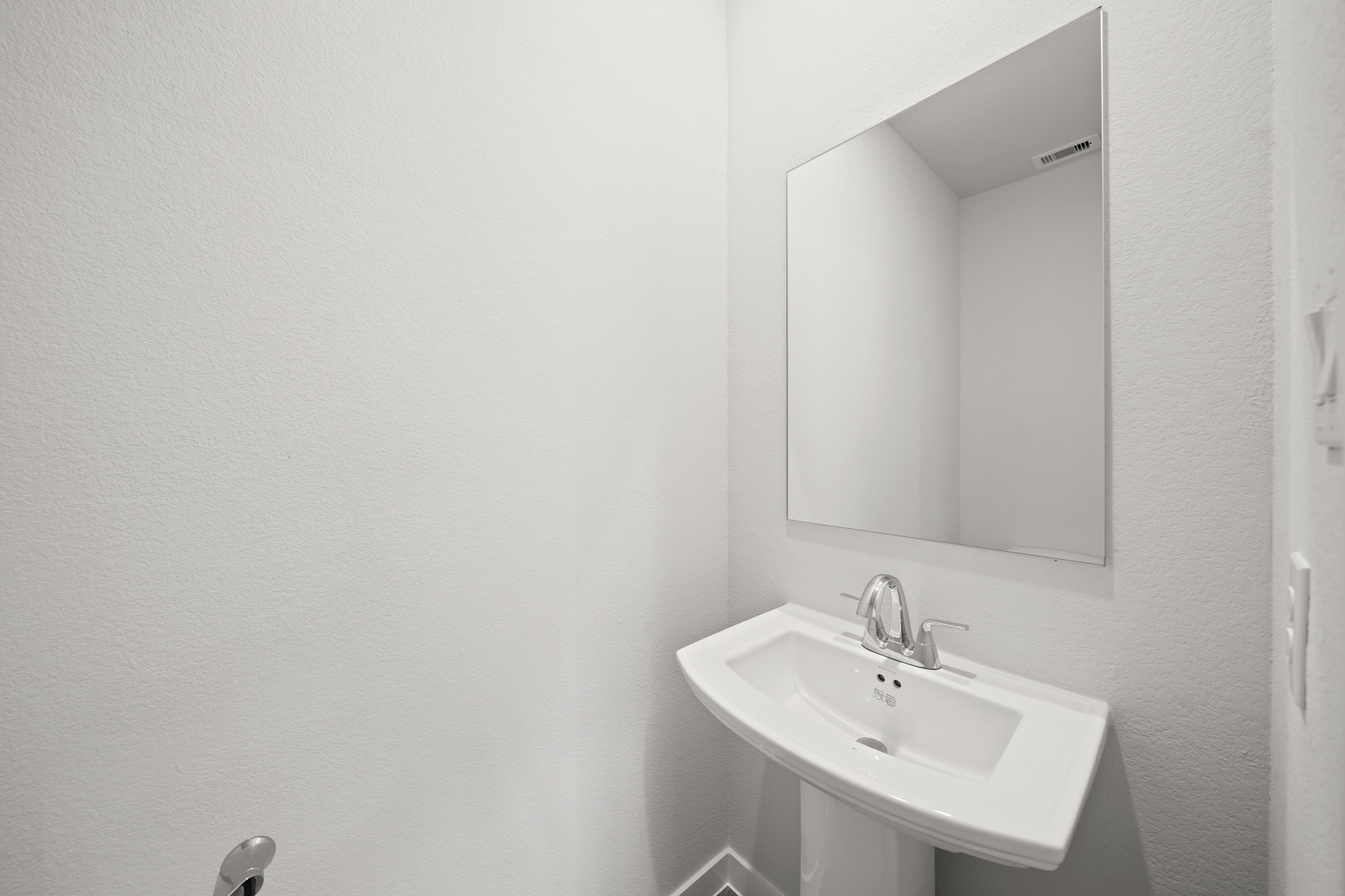 A bathroom with a mirror and sink.