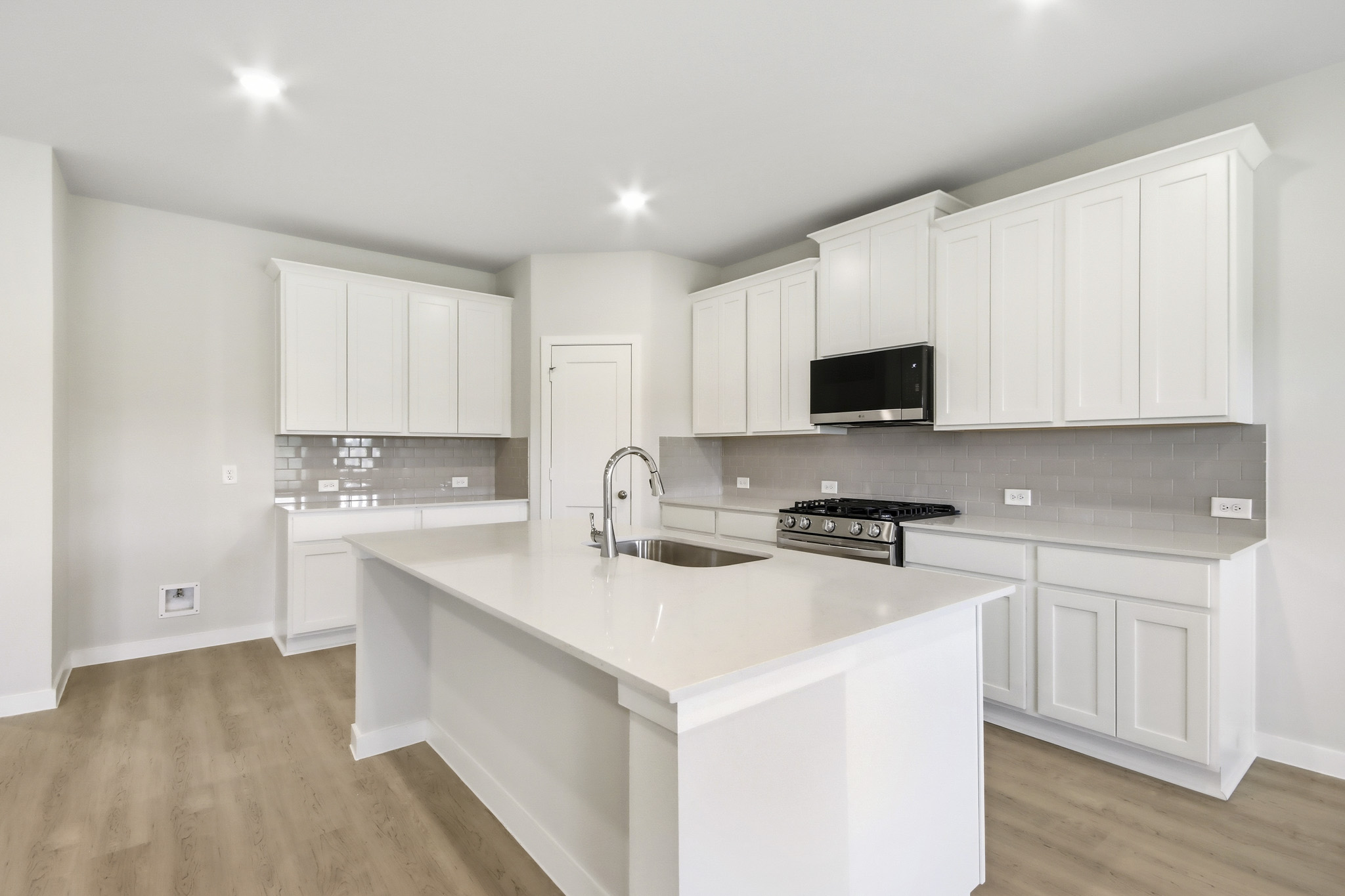 A kitchen with white cabinets.