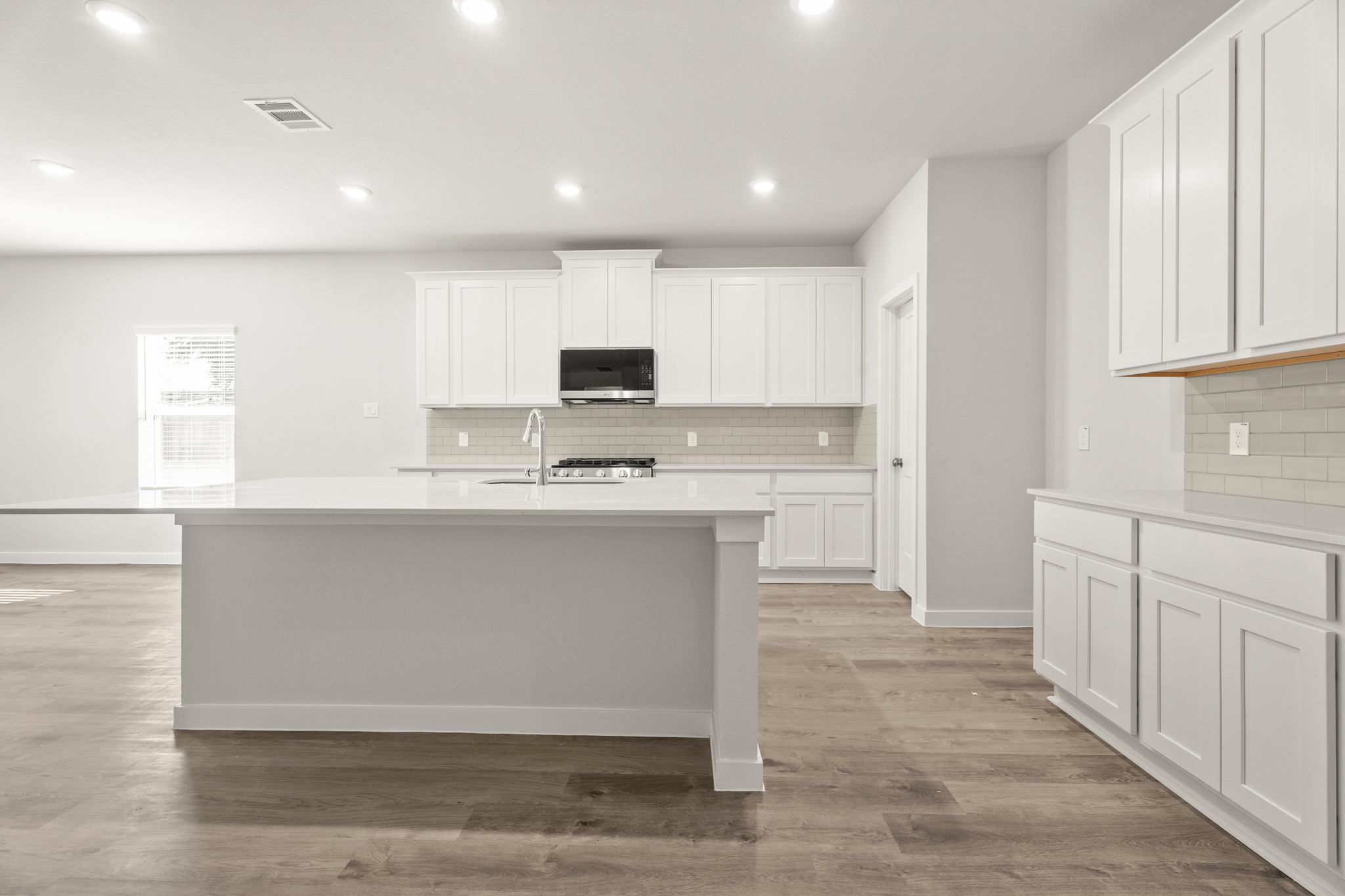 A kitchen with white cabinets.