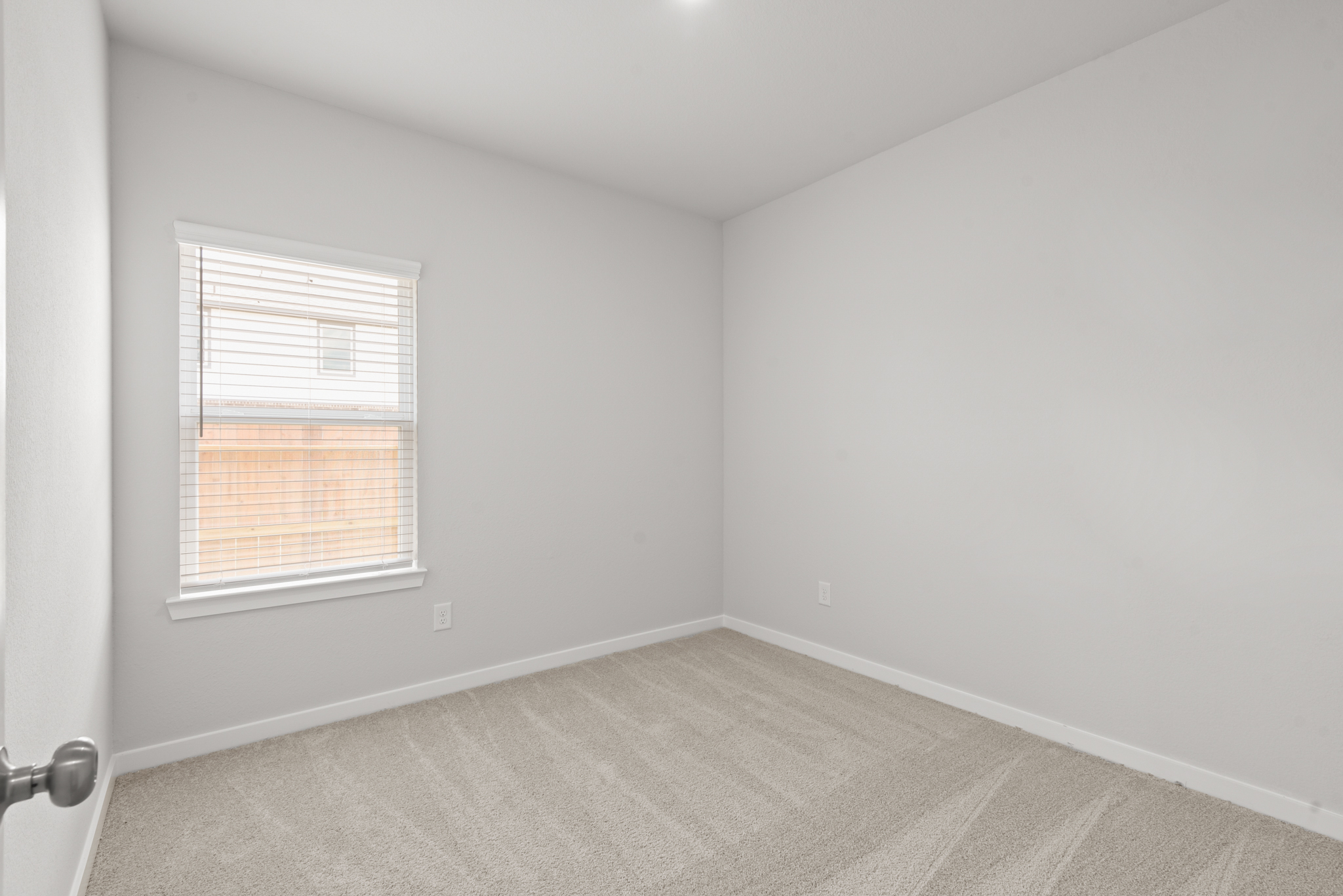 A room with a window and a rug.