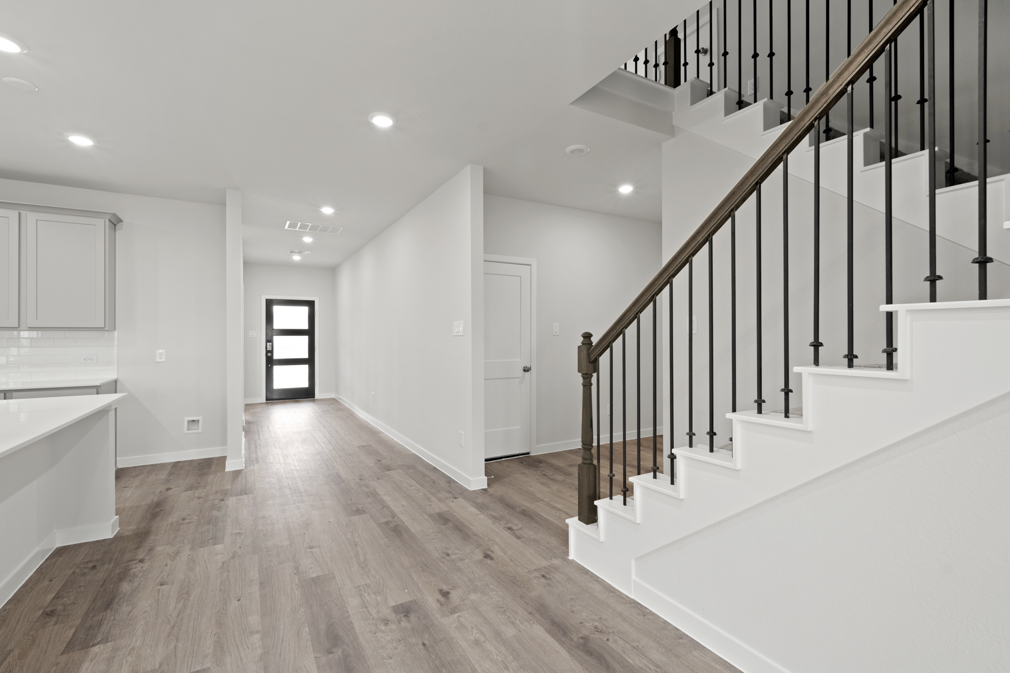 A large white room with a wood floor and white walls.