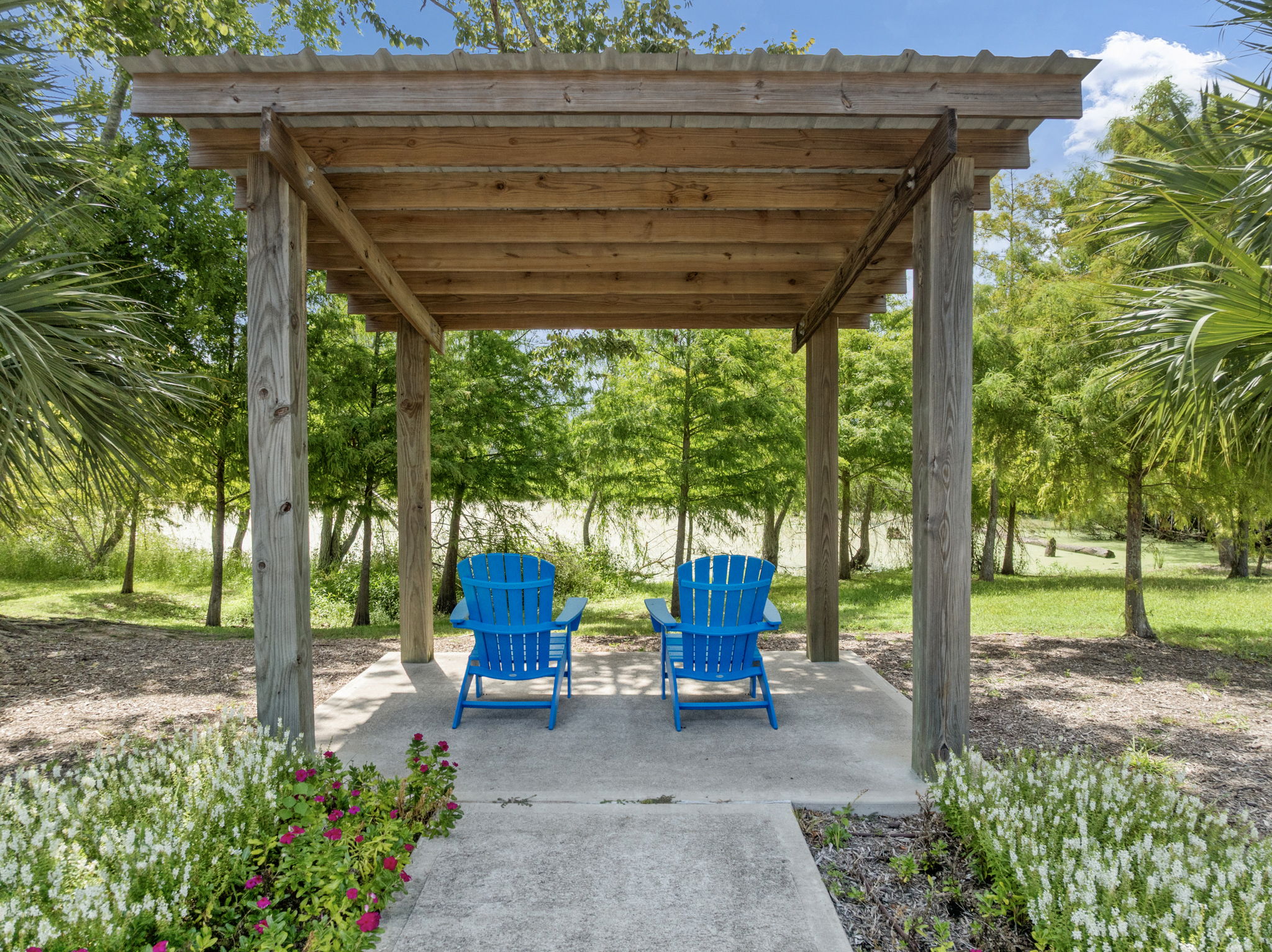 A wood gazebo with blue chairs.
