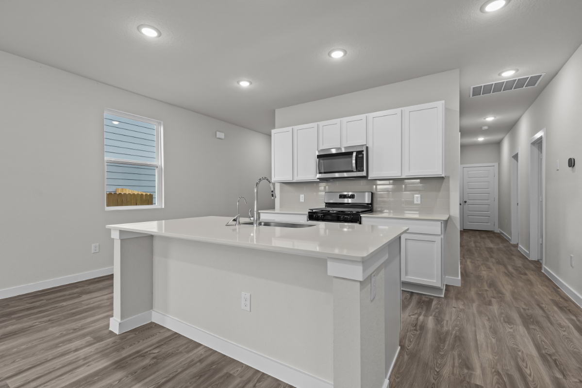 A kitchen with white cabinets.