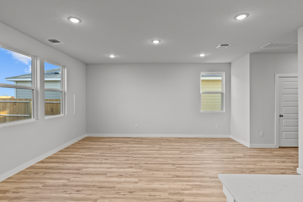 A room with a wood floor and windows.