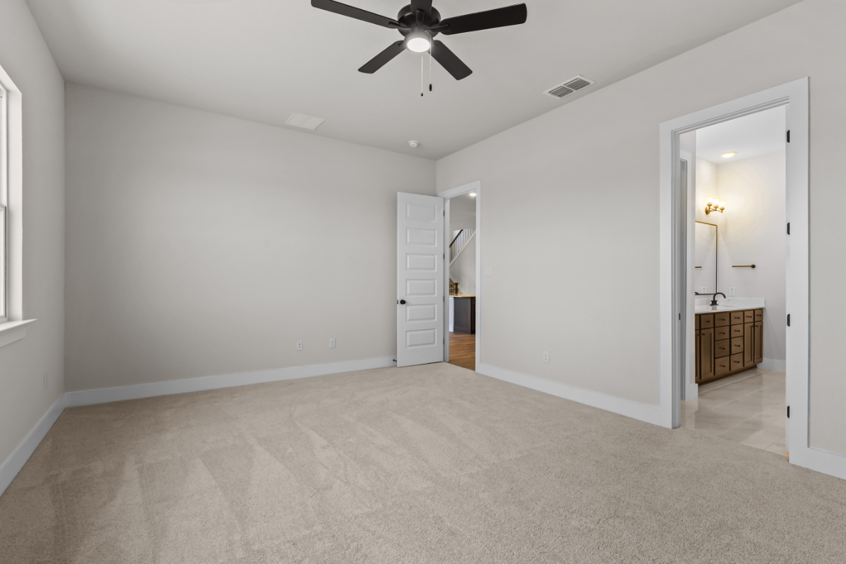 A room with a ceiling fan and a door.