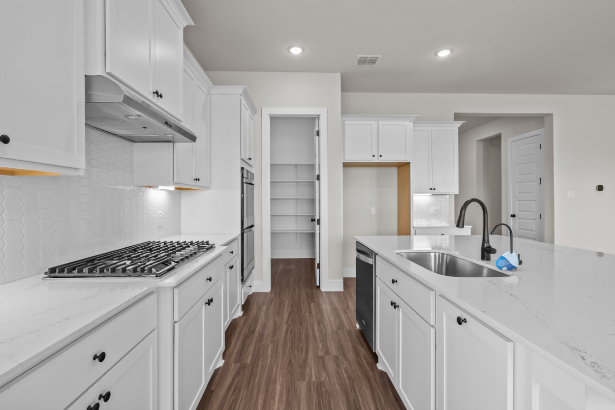 A kitchen with white cabinets.
