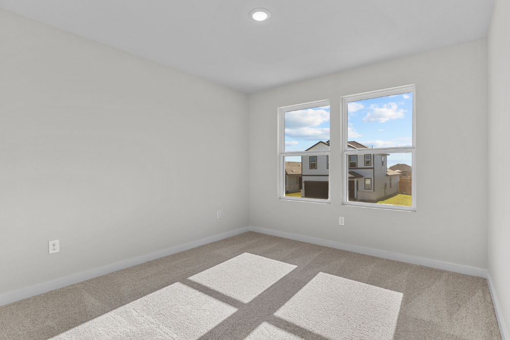 A room with a window and a rug.