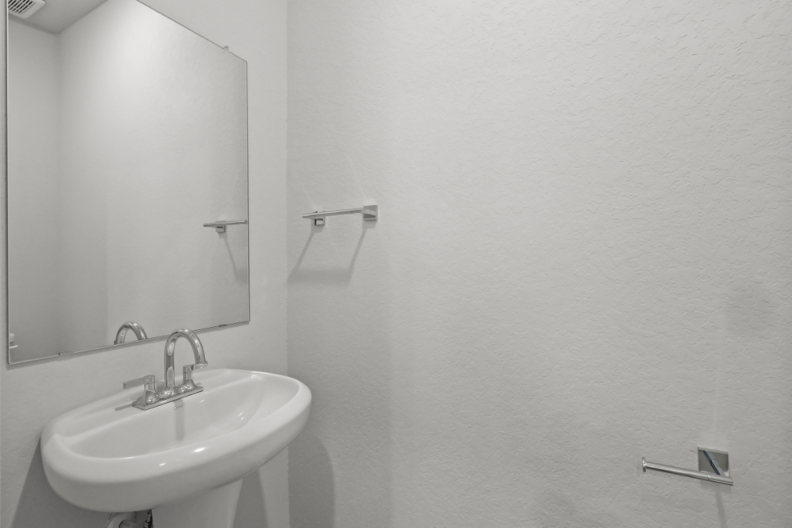 A bathroom with a mirror and sink.