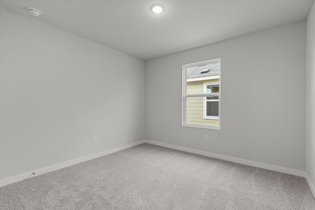 A room with a window and carpet.