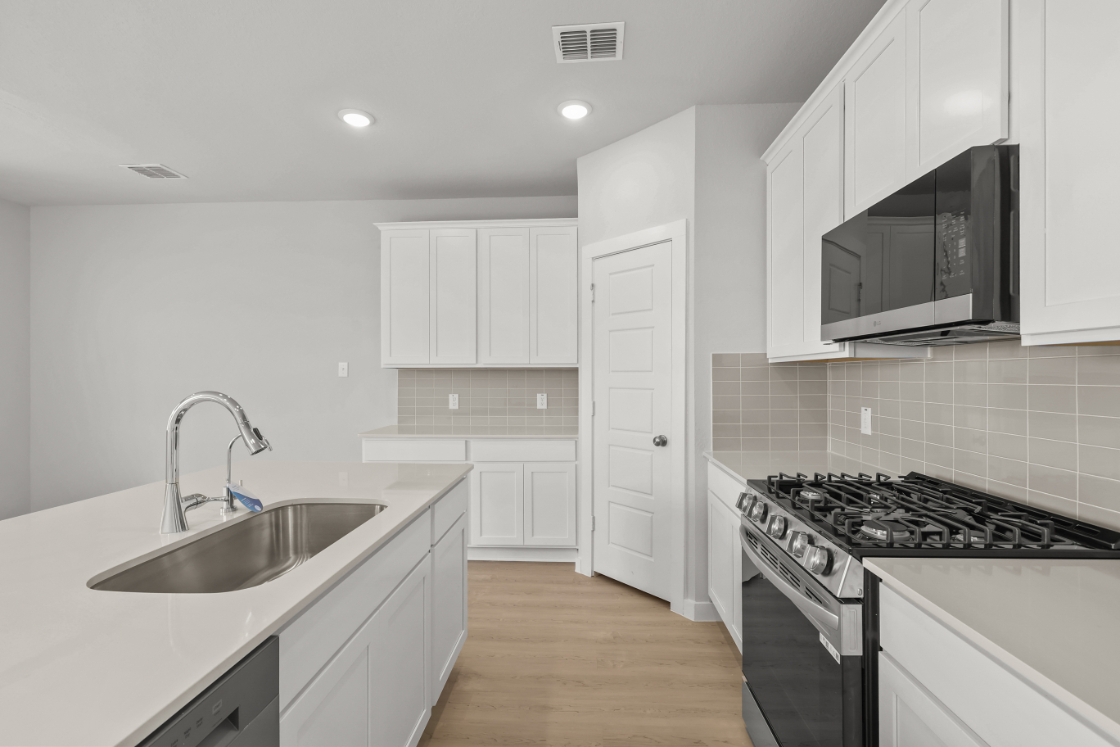 A kitchen with white cabinets.