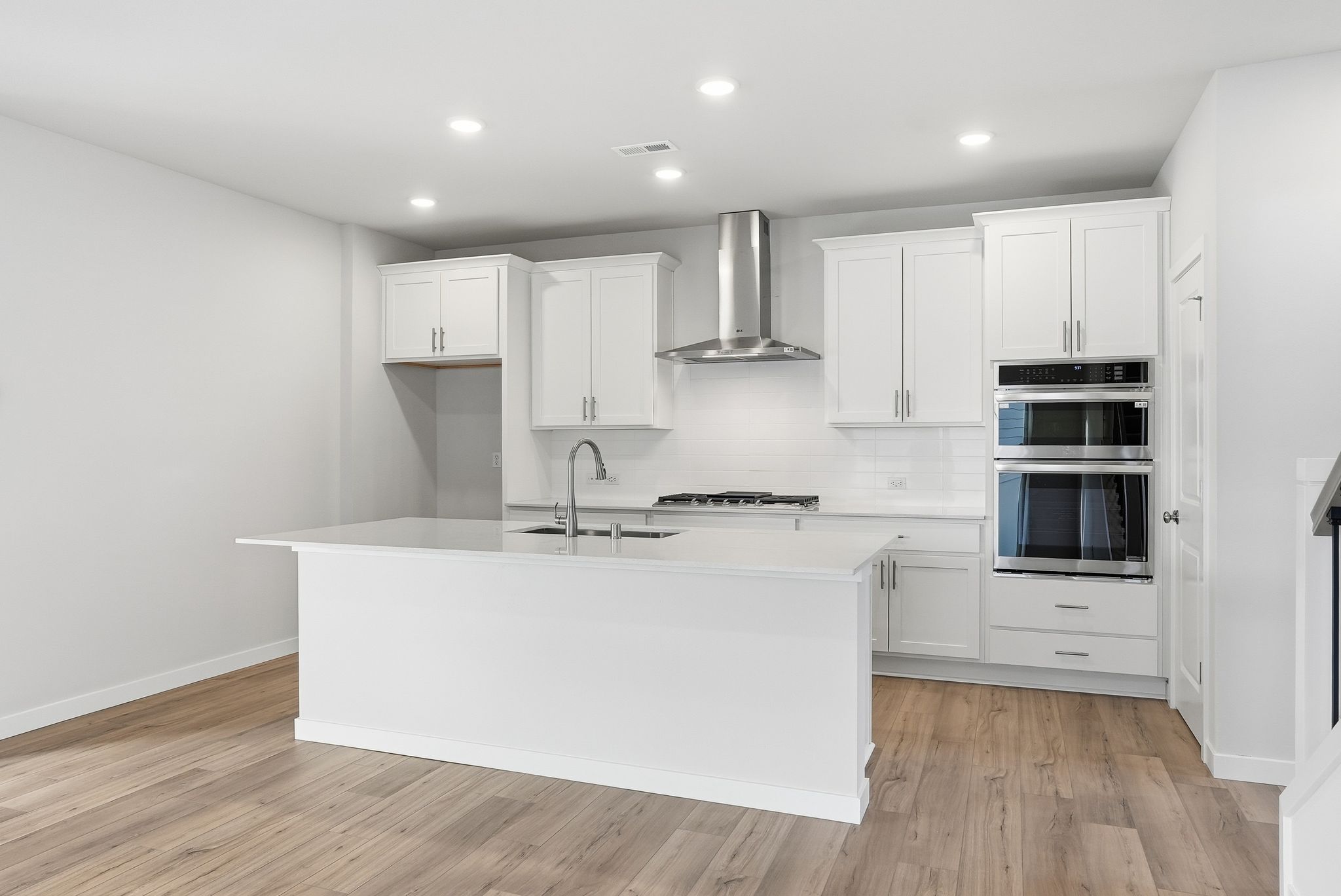 A kitchen with white cabinets.