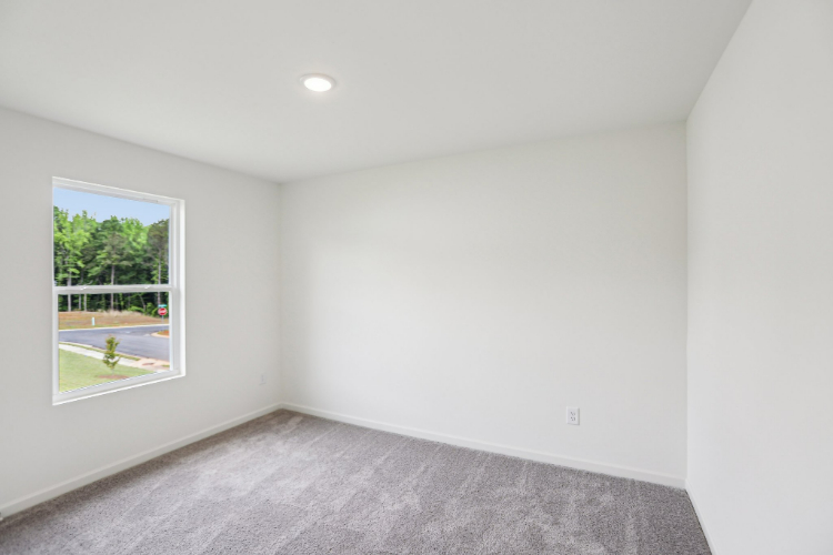 A room with a window and a carpet.