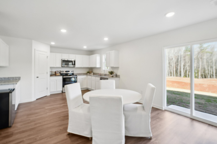 A large kitchen with a large dining table and white chairs.