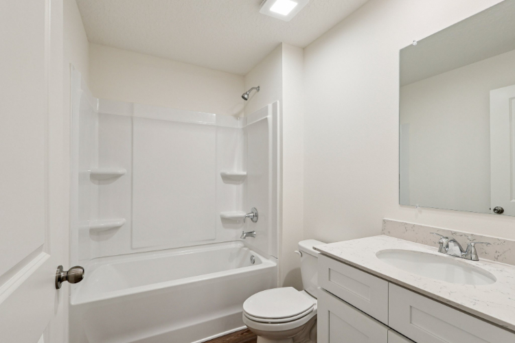 A bathroom with a tub sink and toilet.